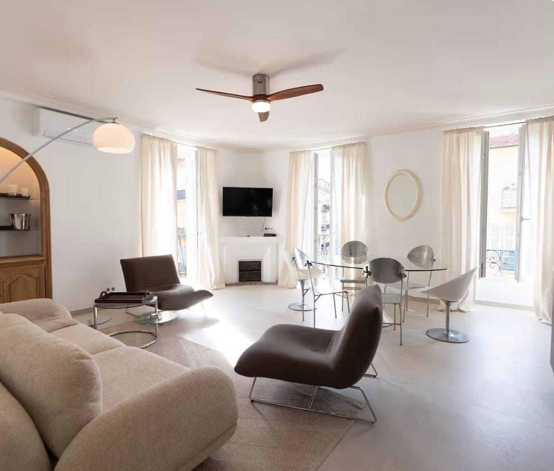 Grand séjour blanc avec trois portes-fenêtres et mobilier design