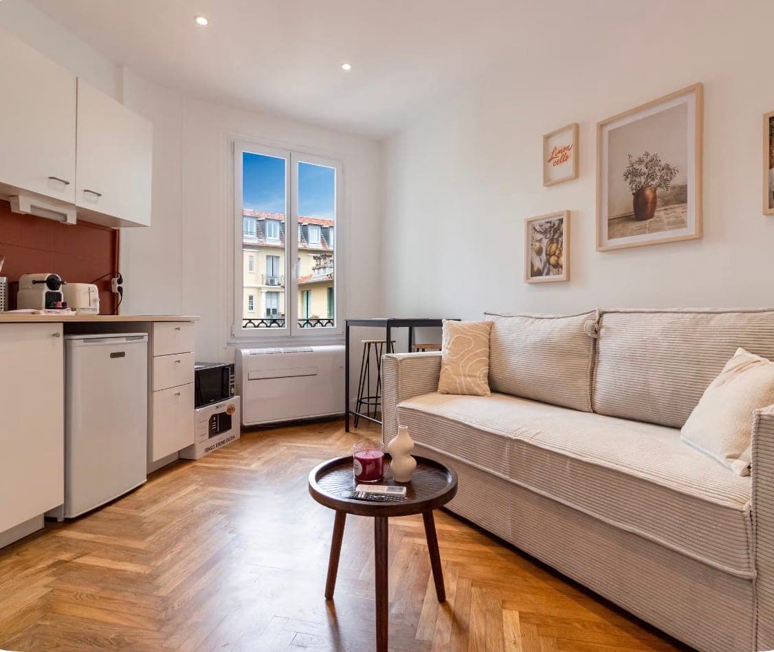 Studio avec cuisine équipée, canapé et fenêtre sur les toits niçois